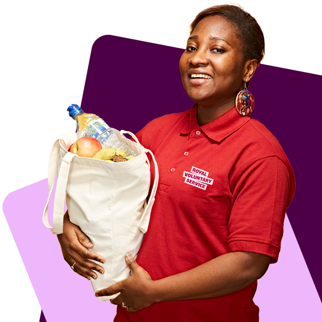 RVS volunteer Amma carrying a bag of shopping for a client and wearing a Royal Voluntary Service T shirt 
