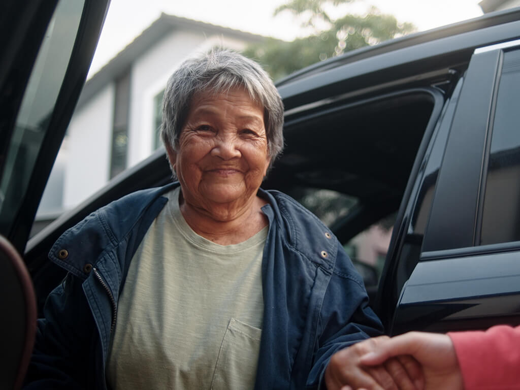 A client getting a lift in a car from a Royal Voluntary Service volunteer