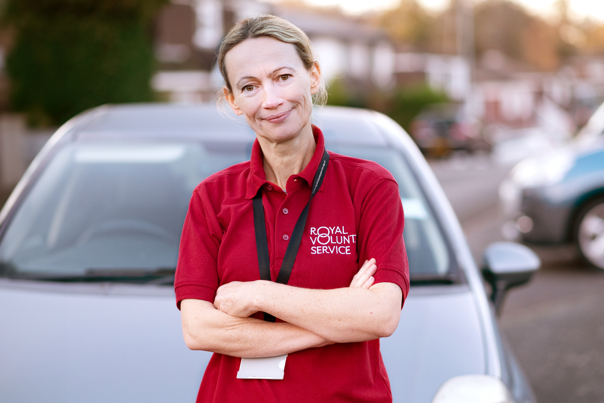 Royal Voluntary Service driving volunteer standing in front of a car