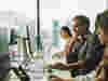 A man in an office sat at a work desk looking at a computer screen 
