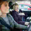 Portrait of a smiling Royal Voluntry Service Patient Transport volunteer in a car with a visitor