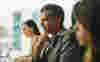 A man sat at a workstation with colleagues 