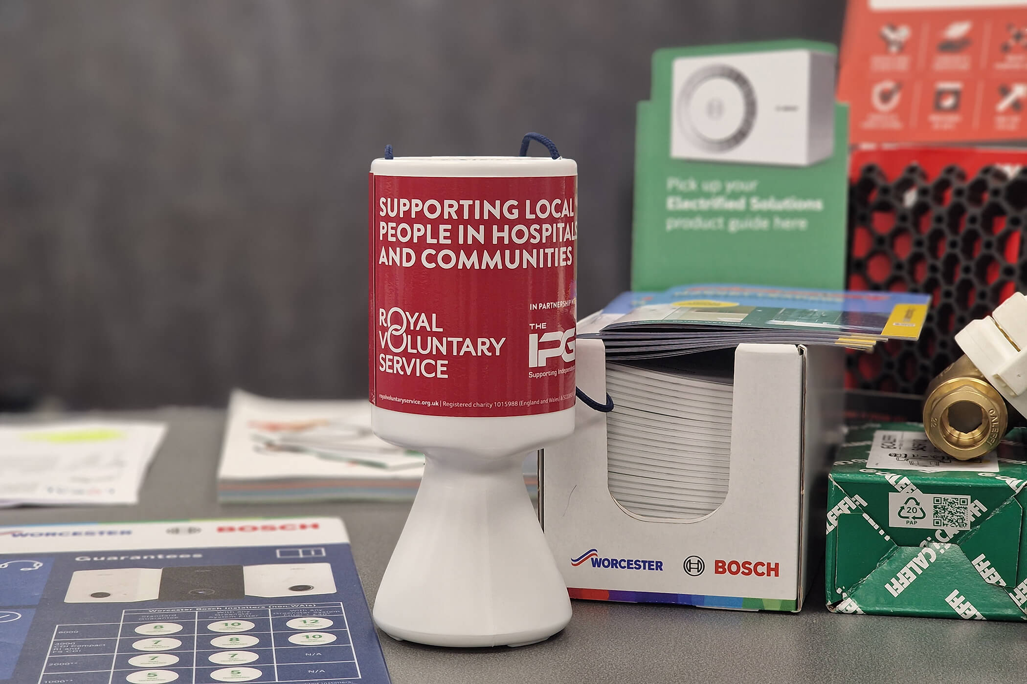 A Royal Voluntary Service collection tin on a shop counter 