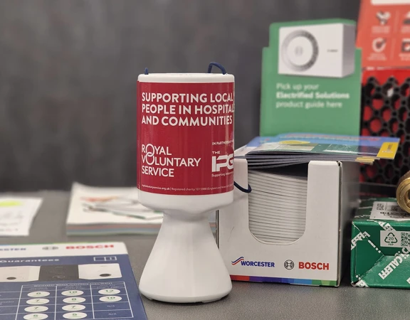 A Royal Voluntary Service collection tin on a shop counter