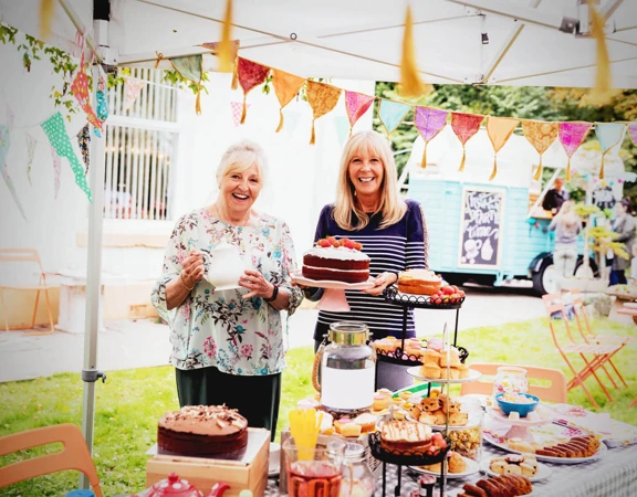 Two woman raising money at a Vintage Tea Party