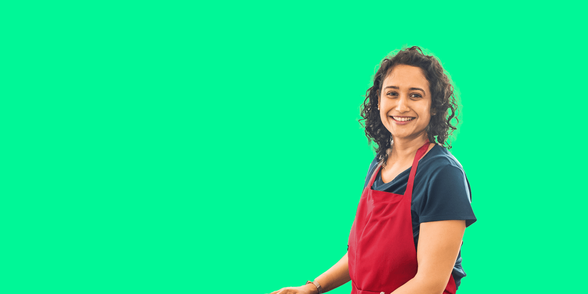 Portrait of volunteer Preeti against an green background 