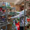 A volunteer at a foodbank stacking shelves
