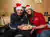 Scott and Georgia in Christmas hats with a plate of mince pies 