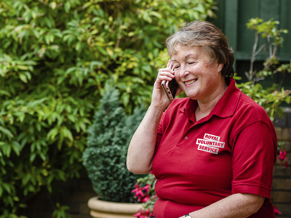A older female volunteer supporting someone from loneliness by having a chat on the phone 