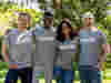 A group of volunteers wearing grey Tshirts lined up arm in arm 