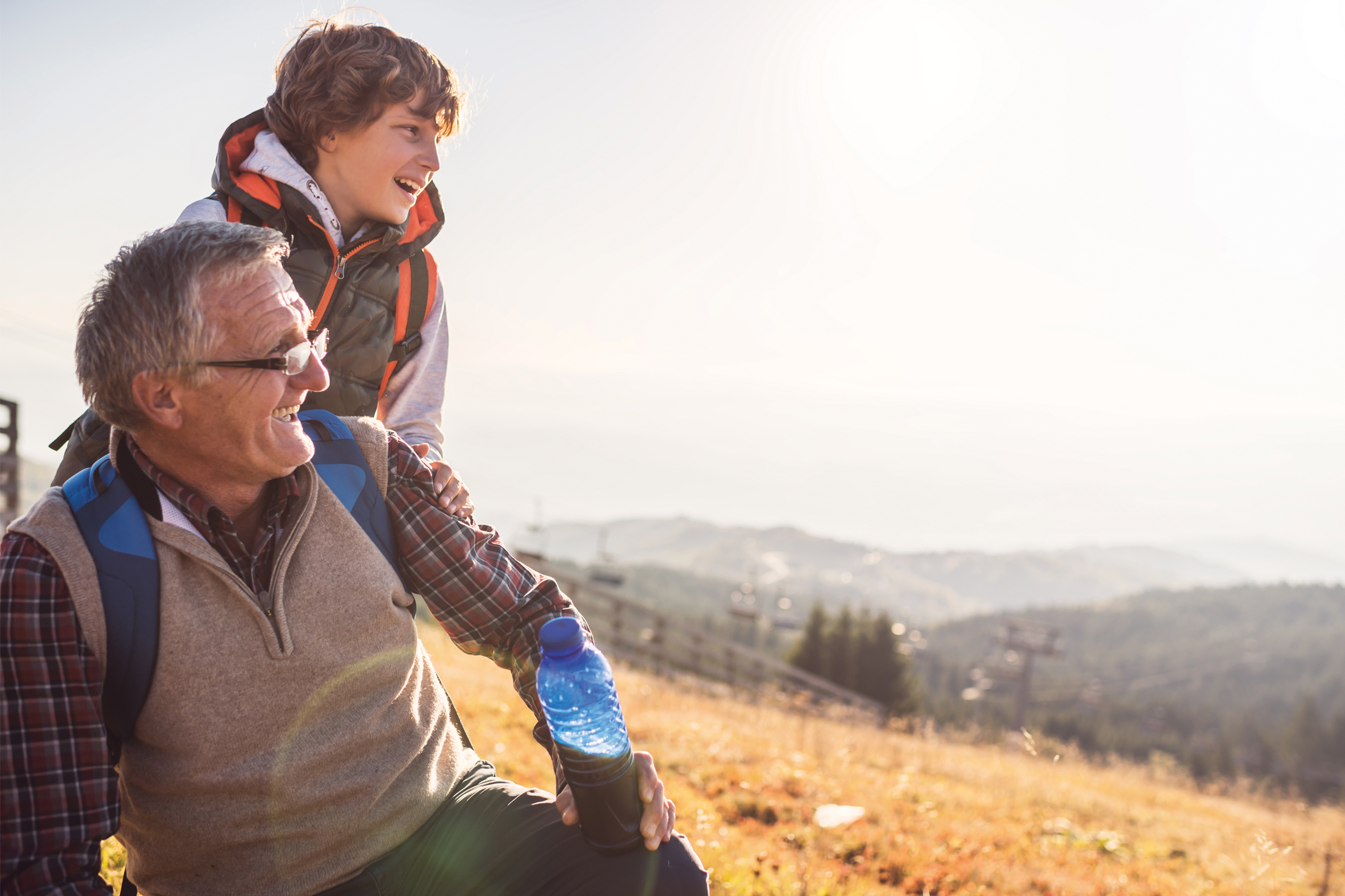 An older man and a young boy on a hike looking at the view 