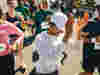 A woman clapping as she finishes a running event