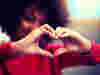 A woman making the symbol of a heart with her hands