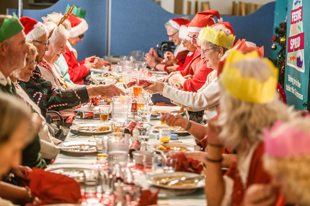 Older people enjoying a Festive Spread Christmas lunch with friends at a social club 