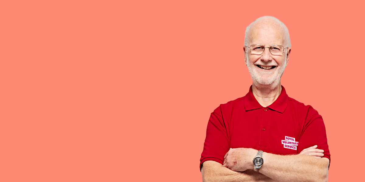 Portrait of volunteer Ian against a light orange background 