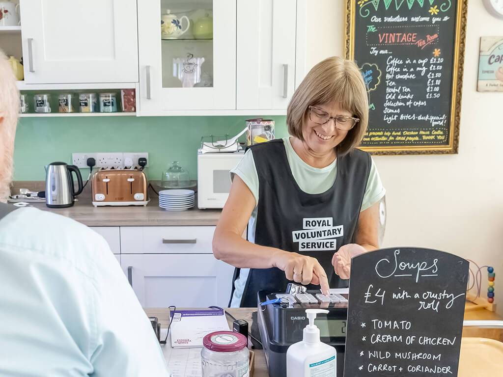 A volunteer serving customers at a community centre 