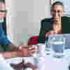 A woman sitting in front of a laptop and leading a meeting