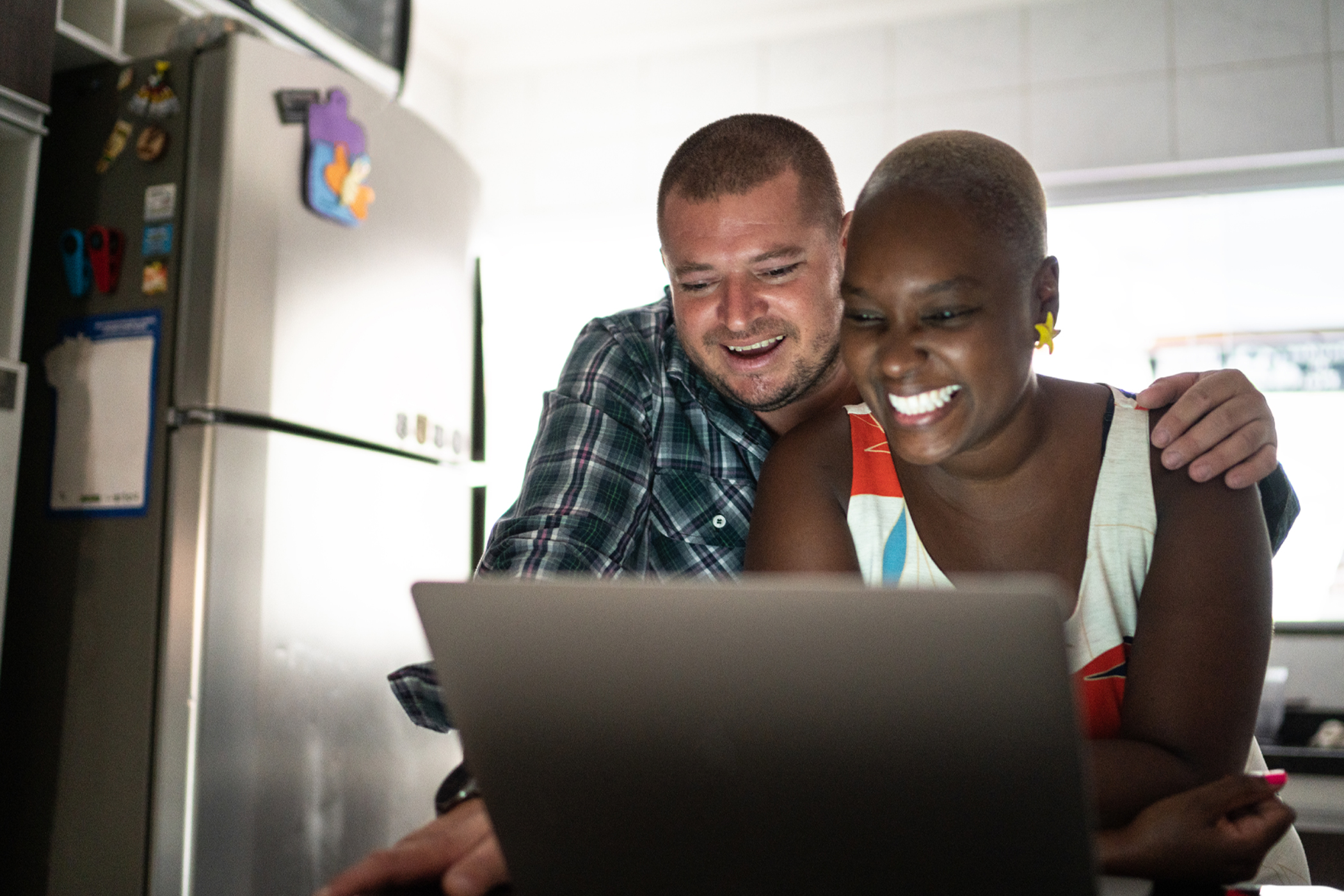 Two people taking part in an online quiz on a lap top computer