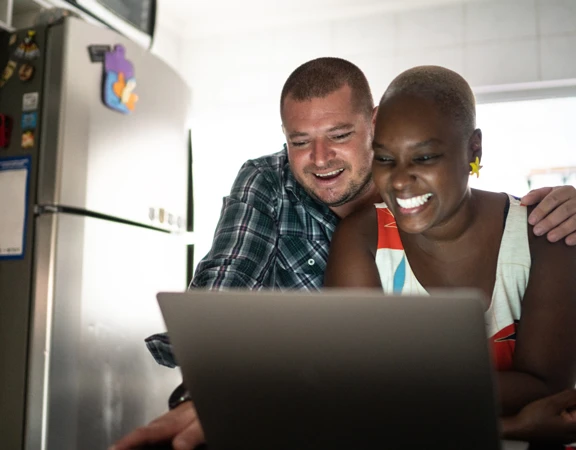 Two people taking part in an online quiz on a lap top computer