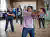 A group of people in a dance fit class in a community centre 