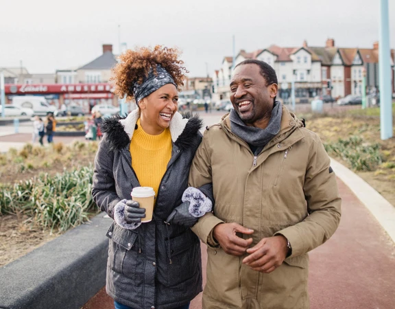 A man and a woman waking arm in arm on a autumn day