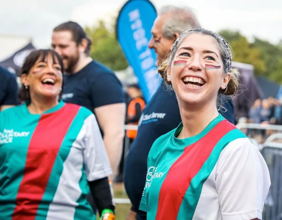 Royal Voluntary Service volunteer smiling at a Tough Mudder event